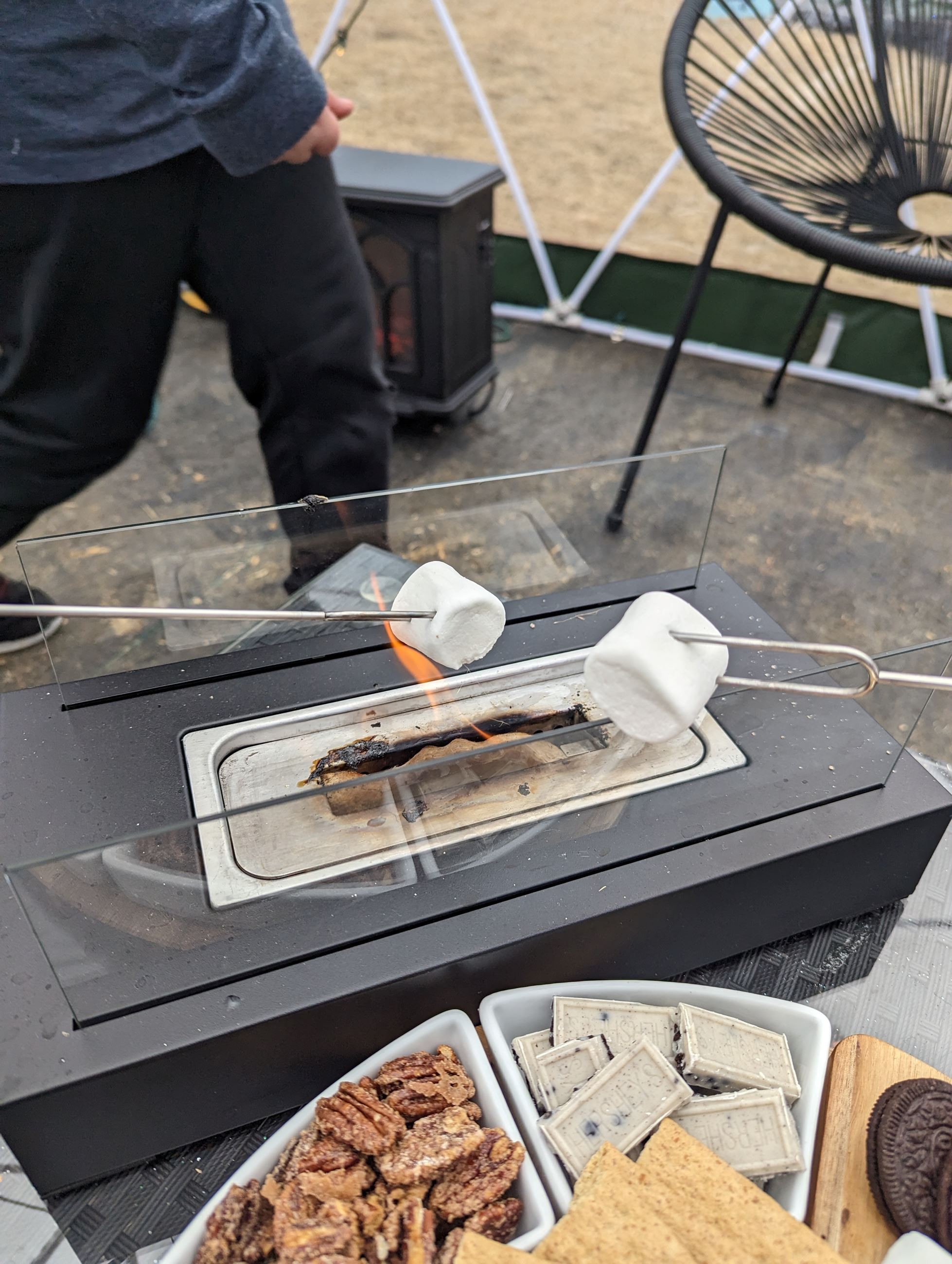 Photo of s'mores and marshmallows being roasted over fire